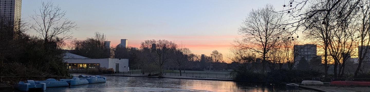 Photo showing the sunrise over Southwark Park lake and cafe building
